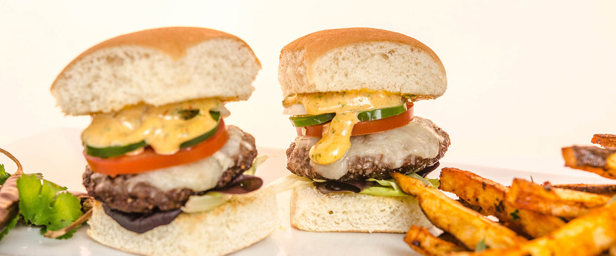 Beef sliders topped with melted cheese, tomato, cucumber, and creamy chipotle sauce.