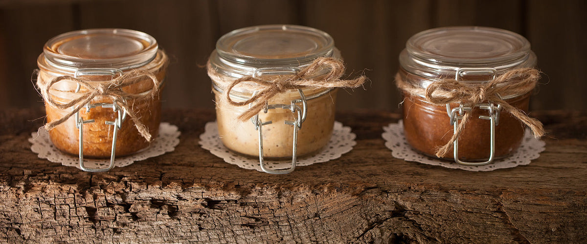 Homemade nut butters in glass jars tied with rustic twine.