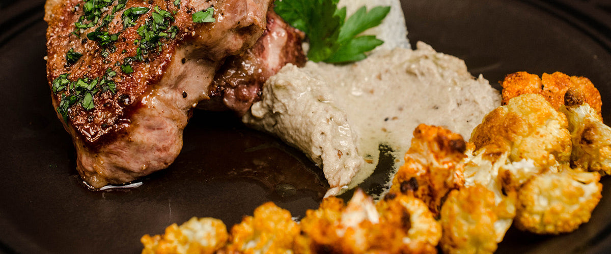Seared lamb chops with roasted spiced cauliflower, creamy purée, and fresh parsley.