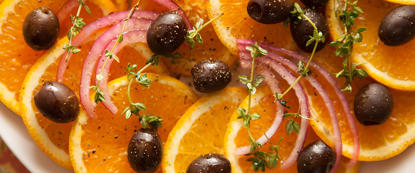 Fresh orange slices topped with black olives, thinly sliced red onion, thyme, cracked black pepper, and olive oil.