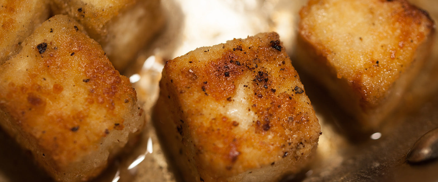 Golden-brown tofu cubes seasoned with black pepper and pan-fried until crisp.