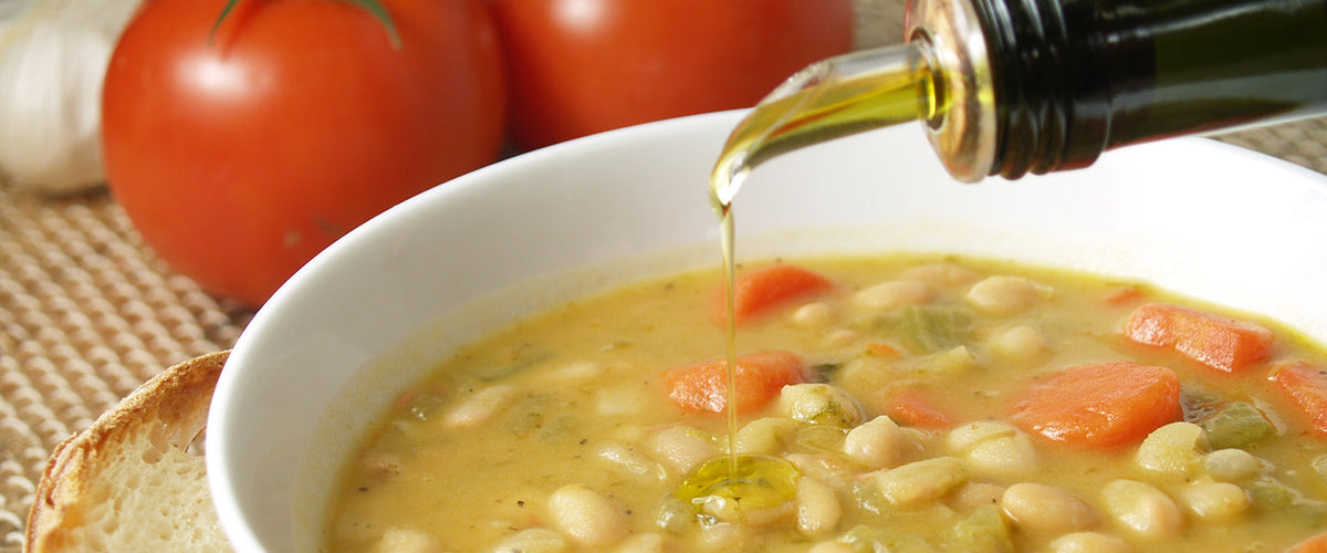 A white bean and vegetable soup with carrots and celery, finished with a drizzle of olive oil.