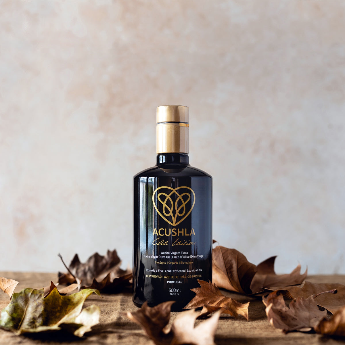 Acushla Gold Edition Organic DOP Trás-os-Montes 500 ml bottle surrounded by dried autumn leaves.