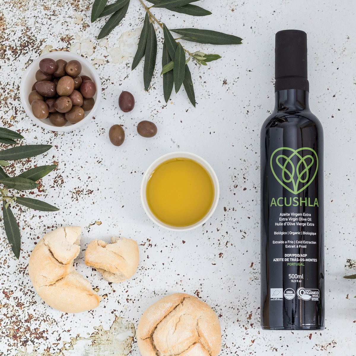 Acushla Organic DOP Trás-os-Montes 500 ml bottle with olive oil, olives, bread, and olive branches.