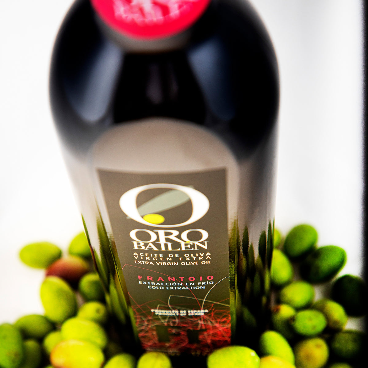 Close-up of Oro Bailen Reserva Familiar Frantoio 500 ml bottle nestled among green olives.