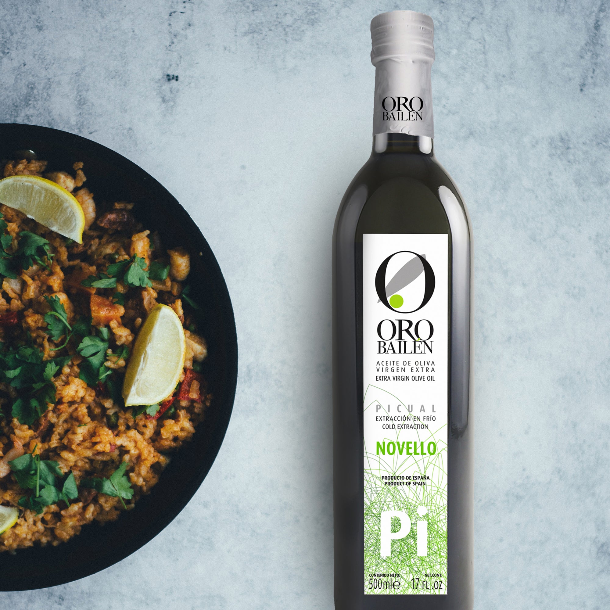 Oro Bailen Picual Novello 500 ml bottle beside a pan of Spanish rice.