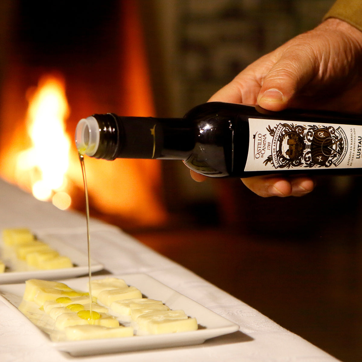 Castillo de Canena Arbequina Amontillado Sherry Cask olive oil poured over cheese.