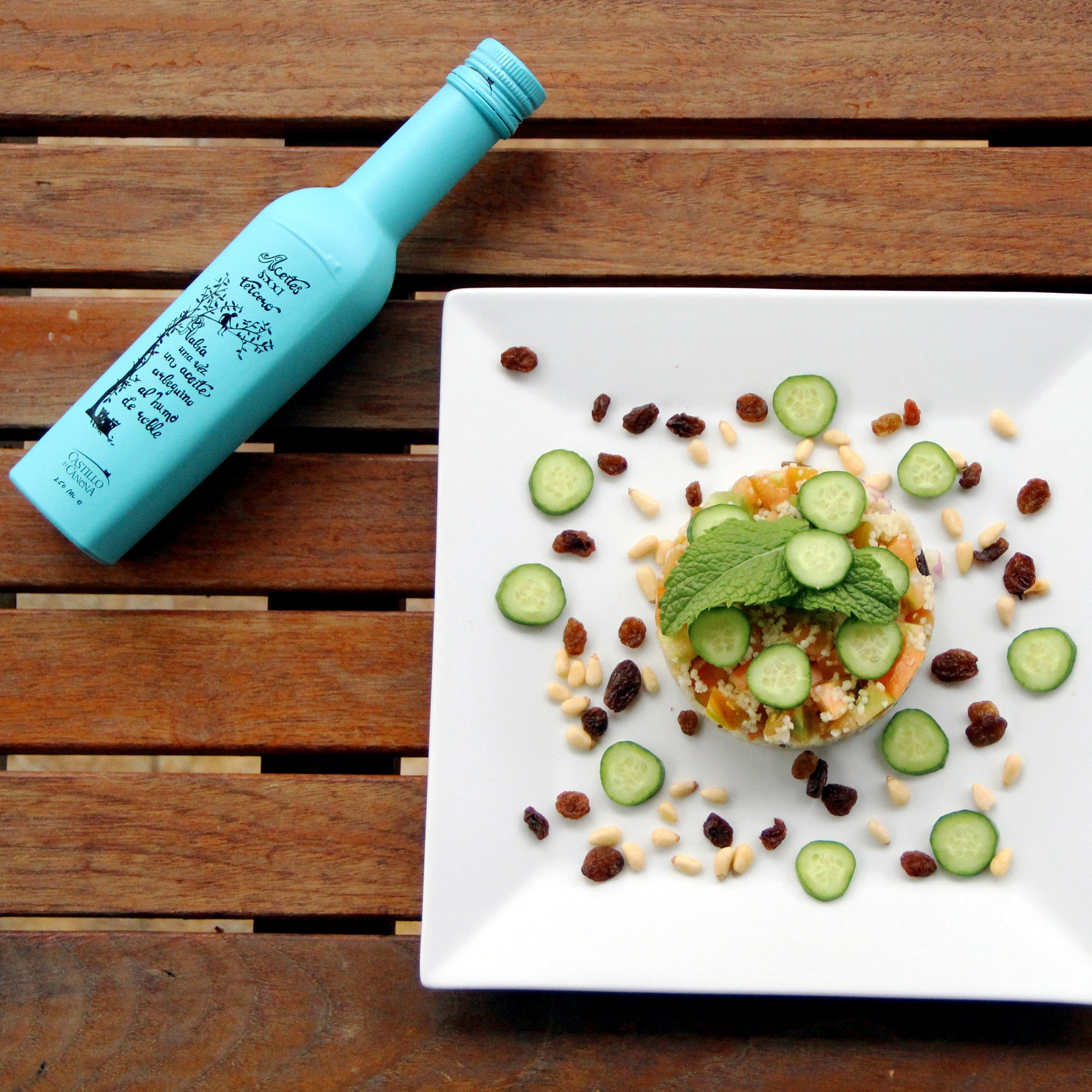 Castillo de Canena Smoked Arbequina 250 ml bottle beside a salad.