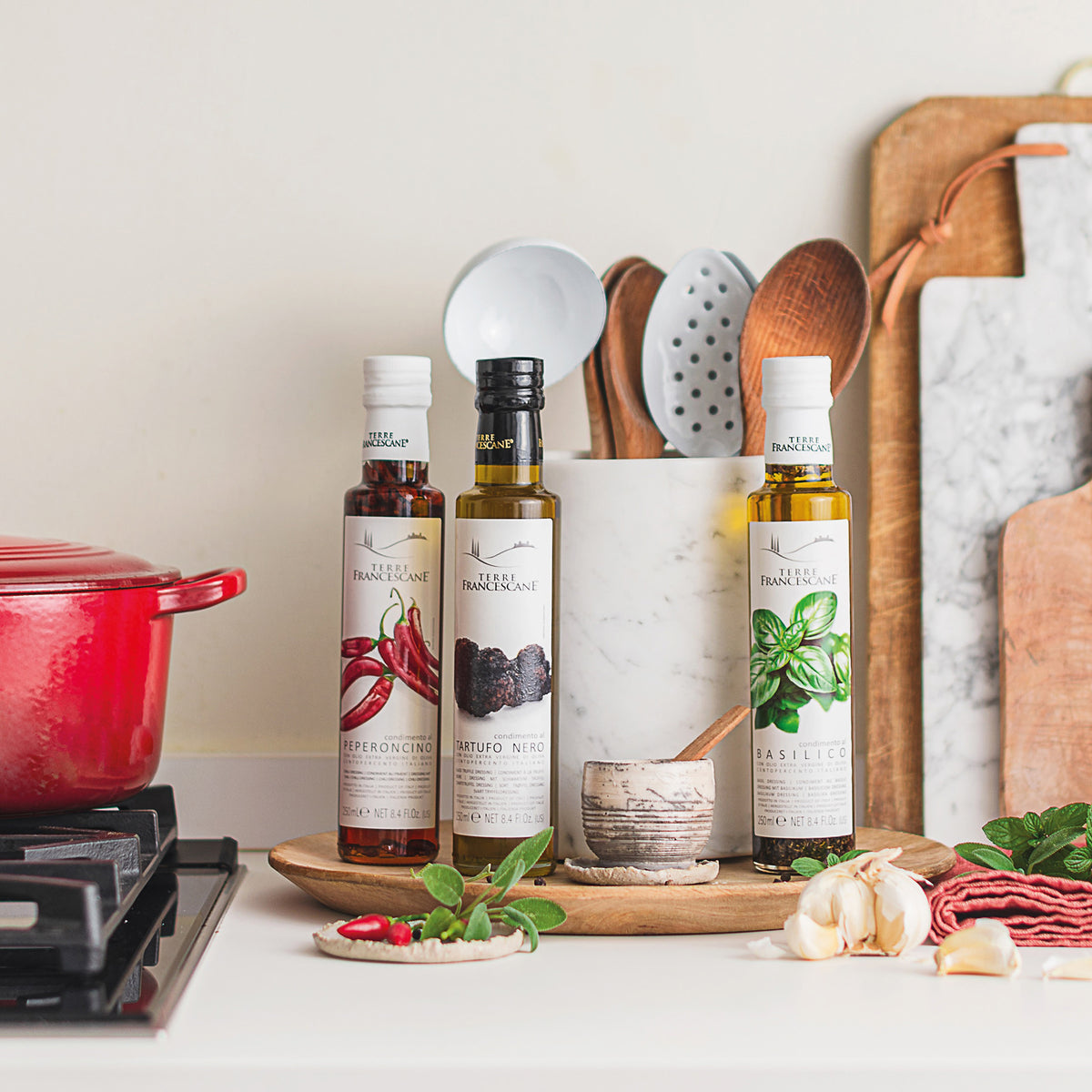 Three 250 ml bottles of Terre Francescane flavored oils; Peperoncino, Black Truffle, and Basil.