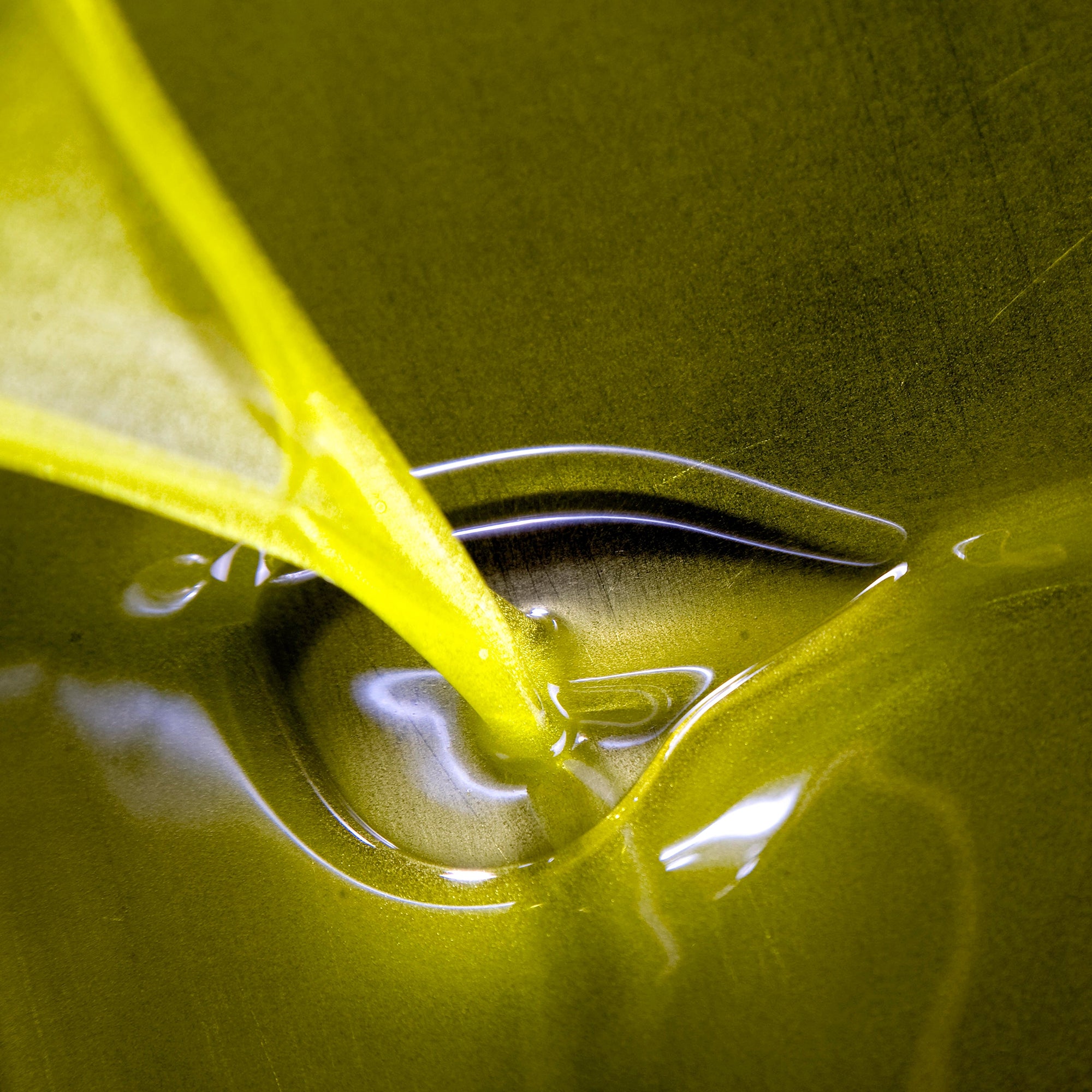 Vivid green olive oil pouring.