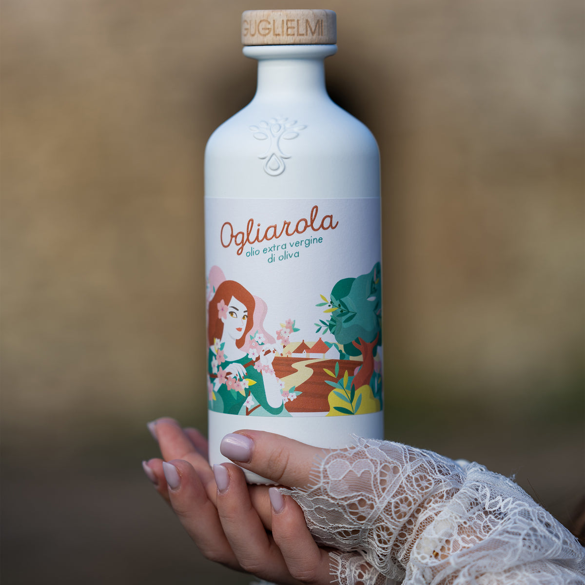 Holding a 500 ml Guglielmi Ogliarola extra virgin olive oil bottle.