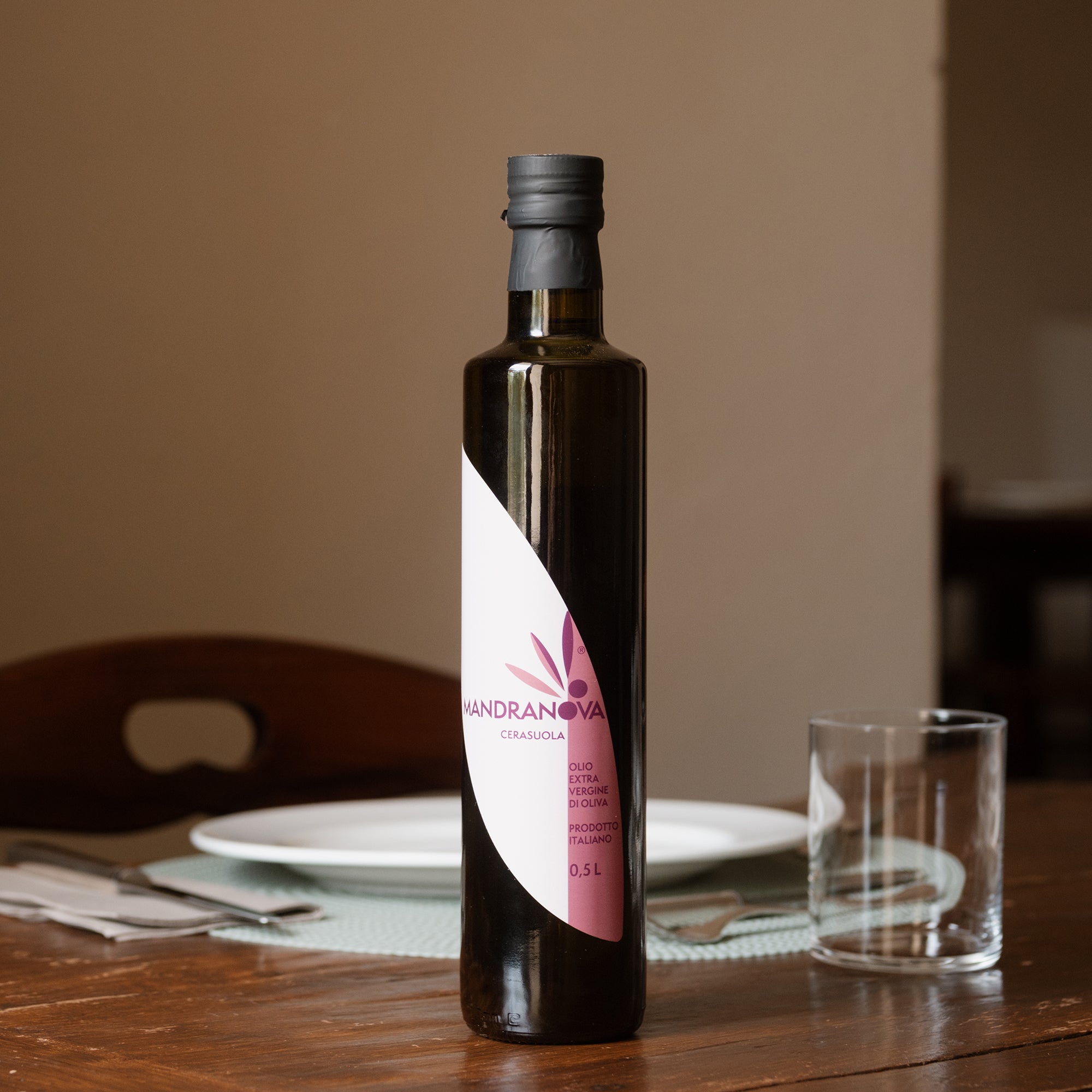 Mandranova Cerasuola extra virgin olive oil bottle on a dining table.