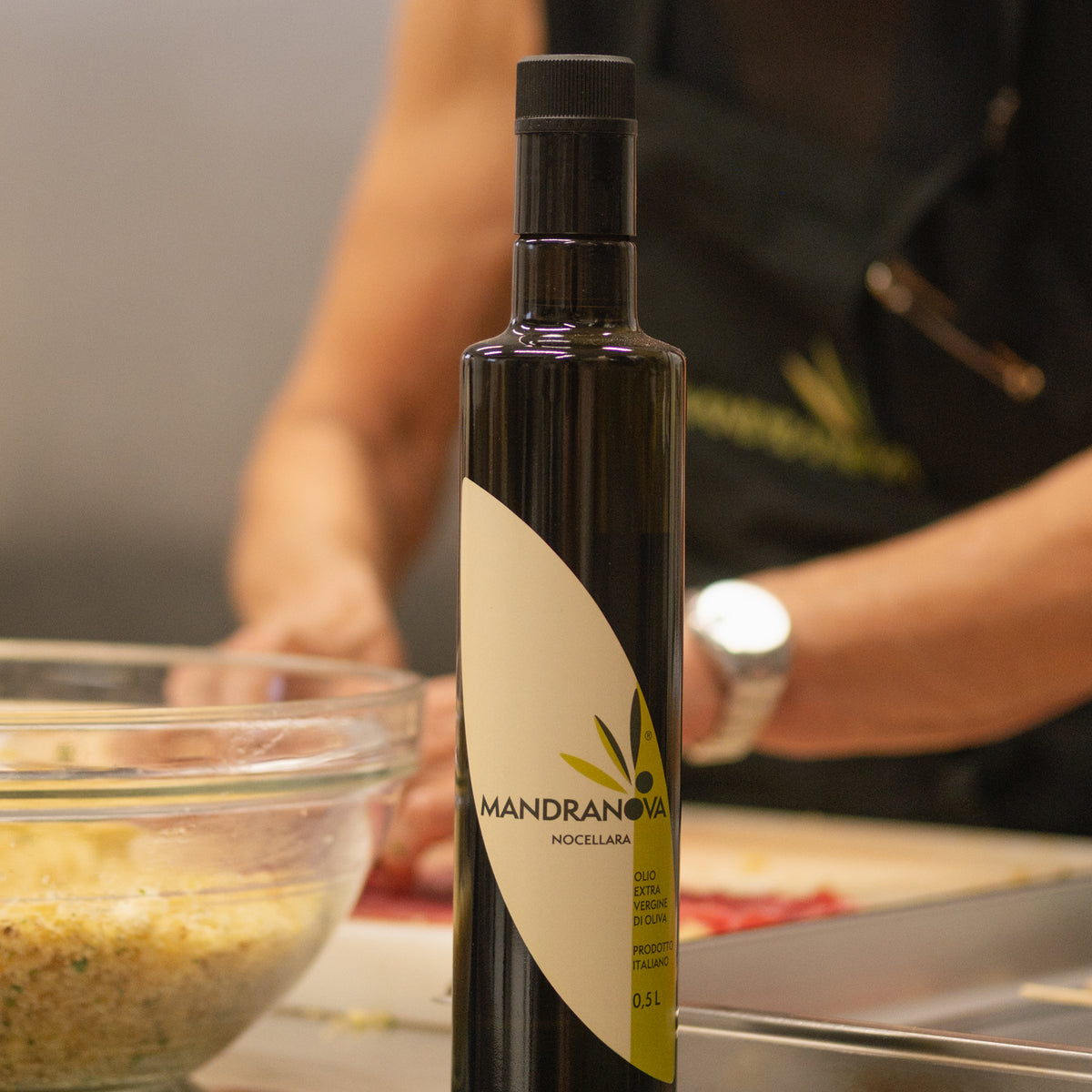 A woman prepares food using Mandranova Nocellara extra virgin olive oil.
