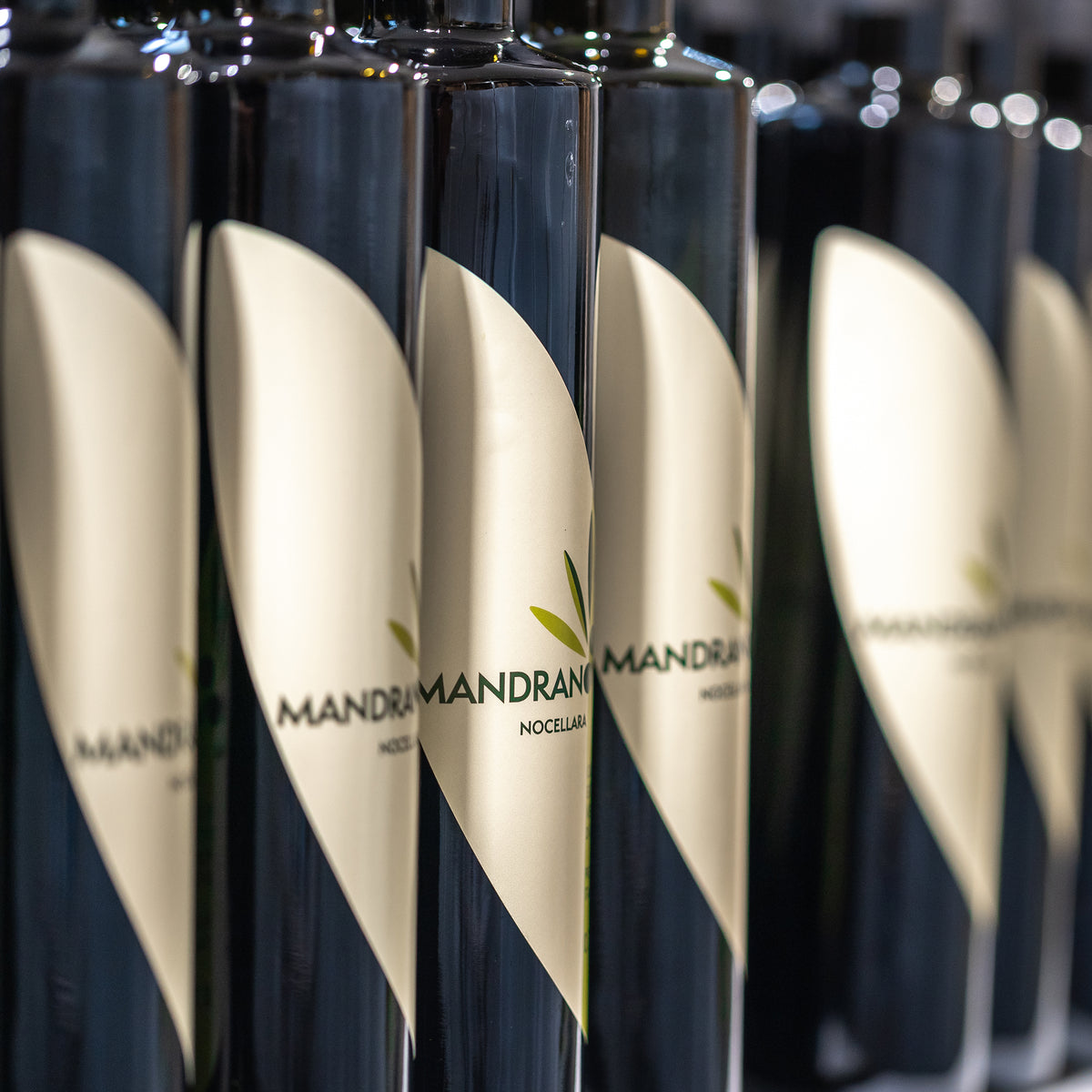 Rows of Mandranova Nocellara 500 ml olive oil bottles during production.