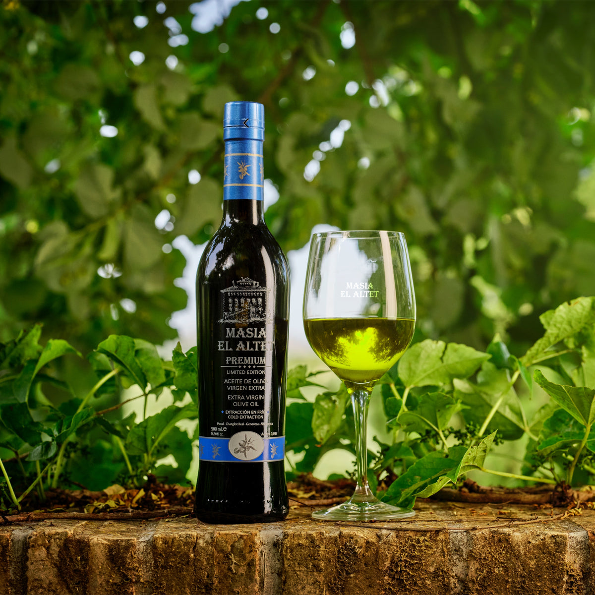 Masia el Altet Premium 500 ml extra virgin olive oil bottle beside a tasting glass.
