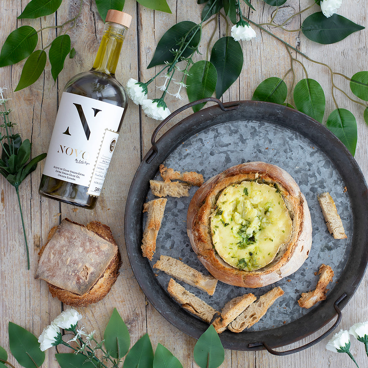 Nobleza del Sur Novo by Lola Sagra 500 ml bottle beside baked cheese in bread.