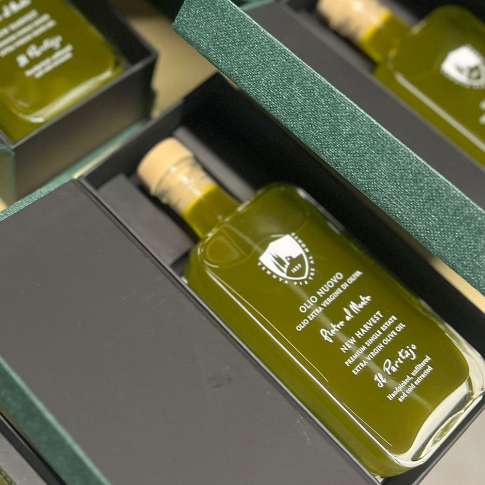 Pietre al Monte Olio Nuovo bottles inside open gift boxes.
