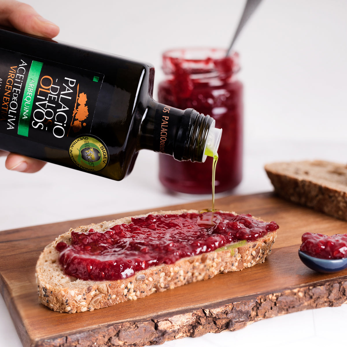 Palacio de los Olivos Arbequina olive oil drizzled over seeded bread with red berry jam.