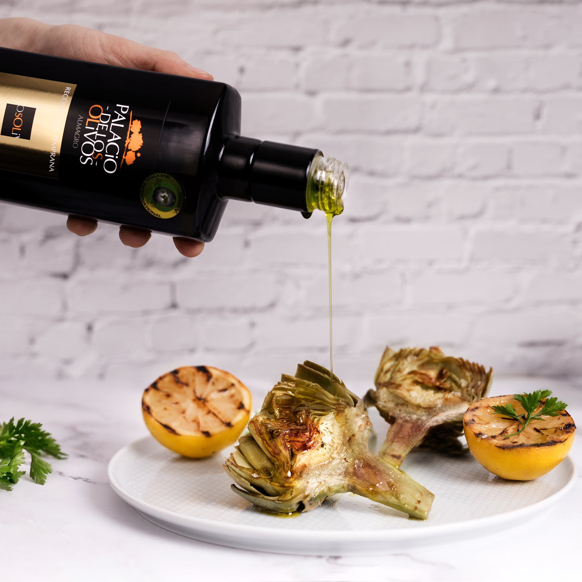Palacio de los Olivos Picual olive oil drizzled over grilled artichokes with charred lemons and parsley.