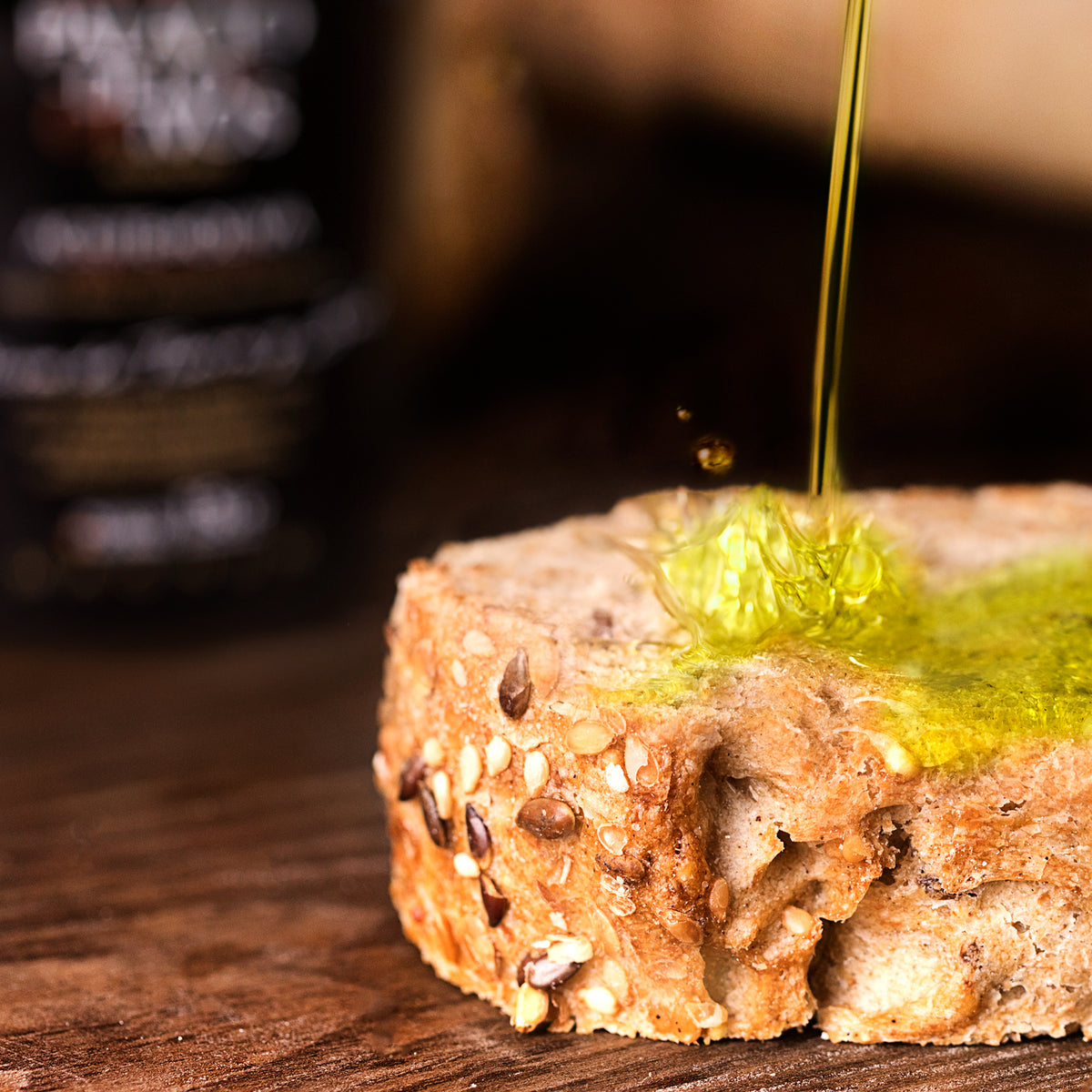 Palacio de los Olivos olive oil pouring onto seeded bread.