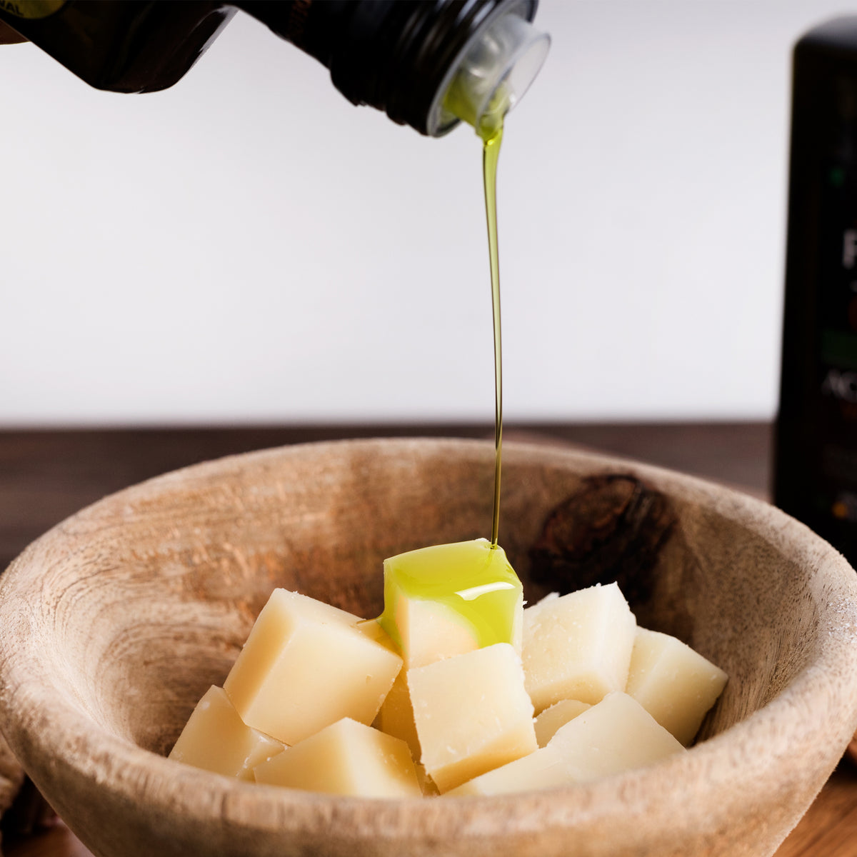 Palacio de los Olivos olive oil pouring over cubes of aged cheese.