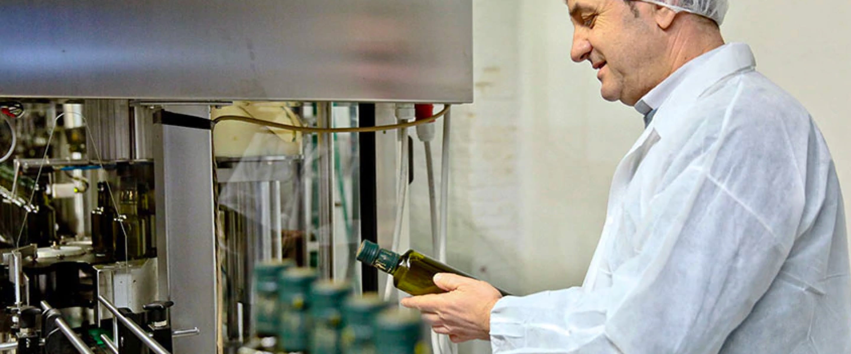 Olive Oil Lovers staff examining a bottle on the production line.