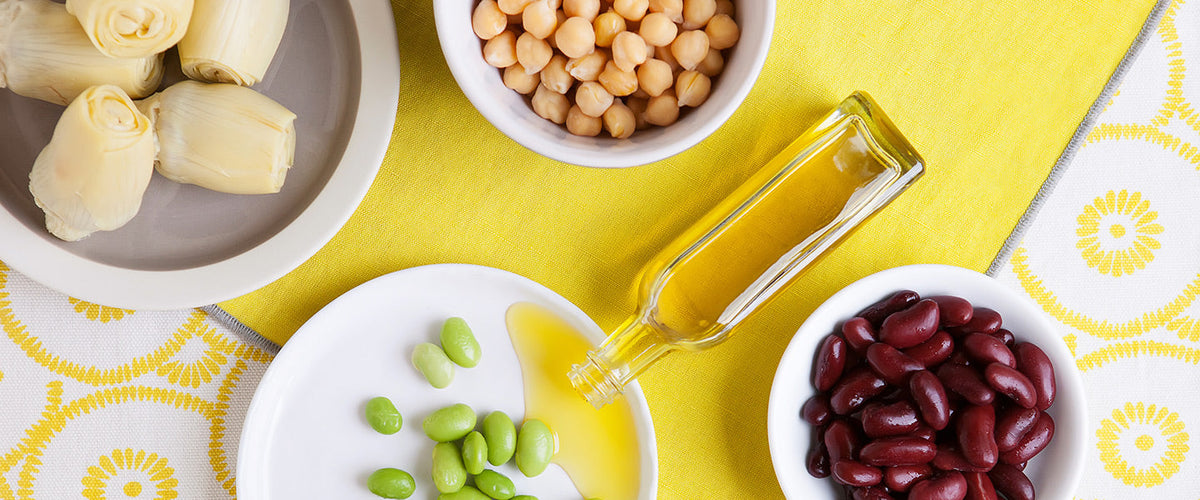 Mixed bean salad ingredients: chickpeas, kidney beans, edamame, artichoke hearts, and olive oil.
