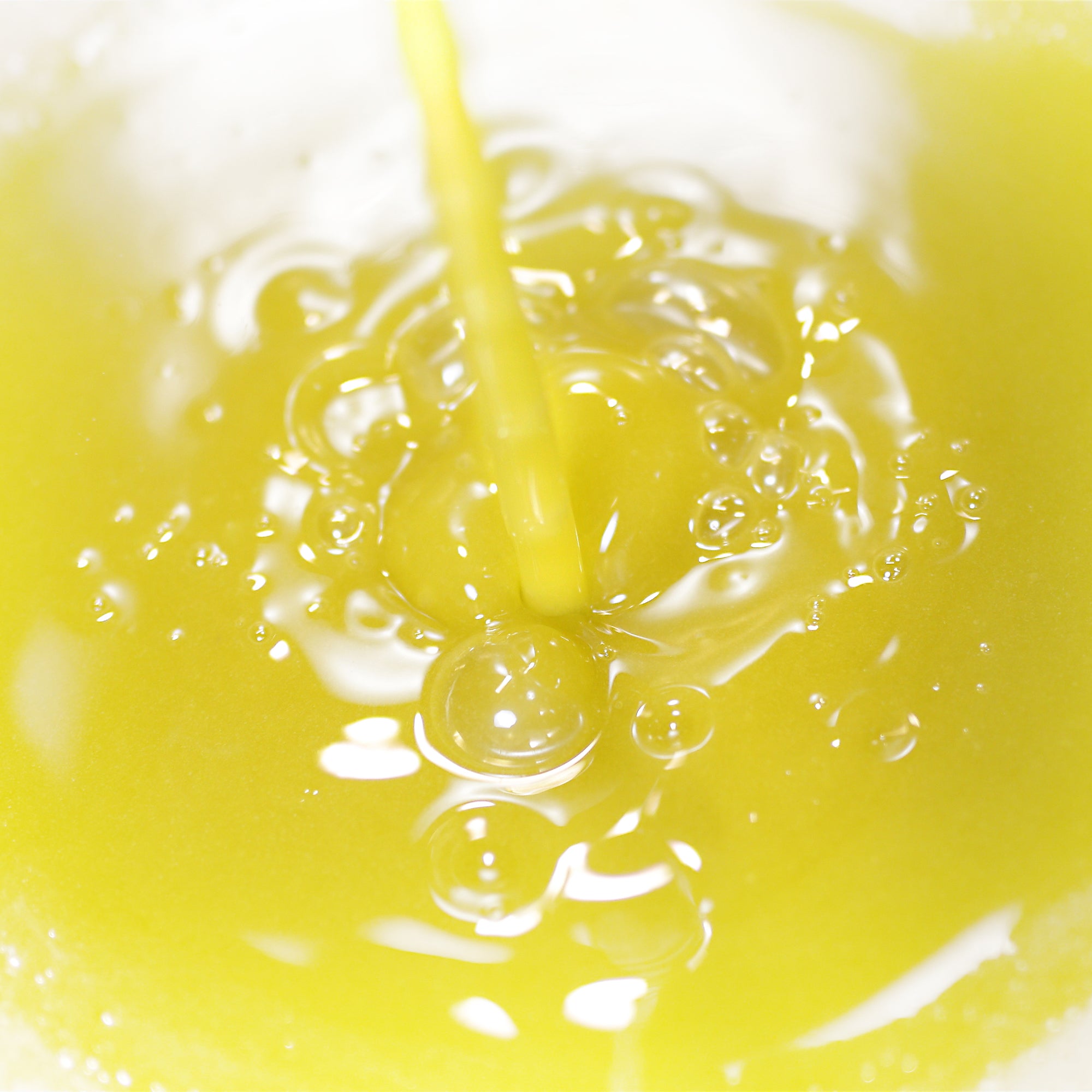 Pouring vivid green freshly produced olive oil.