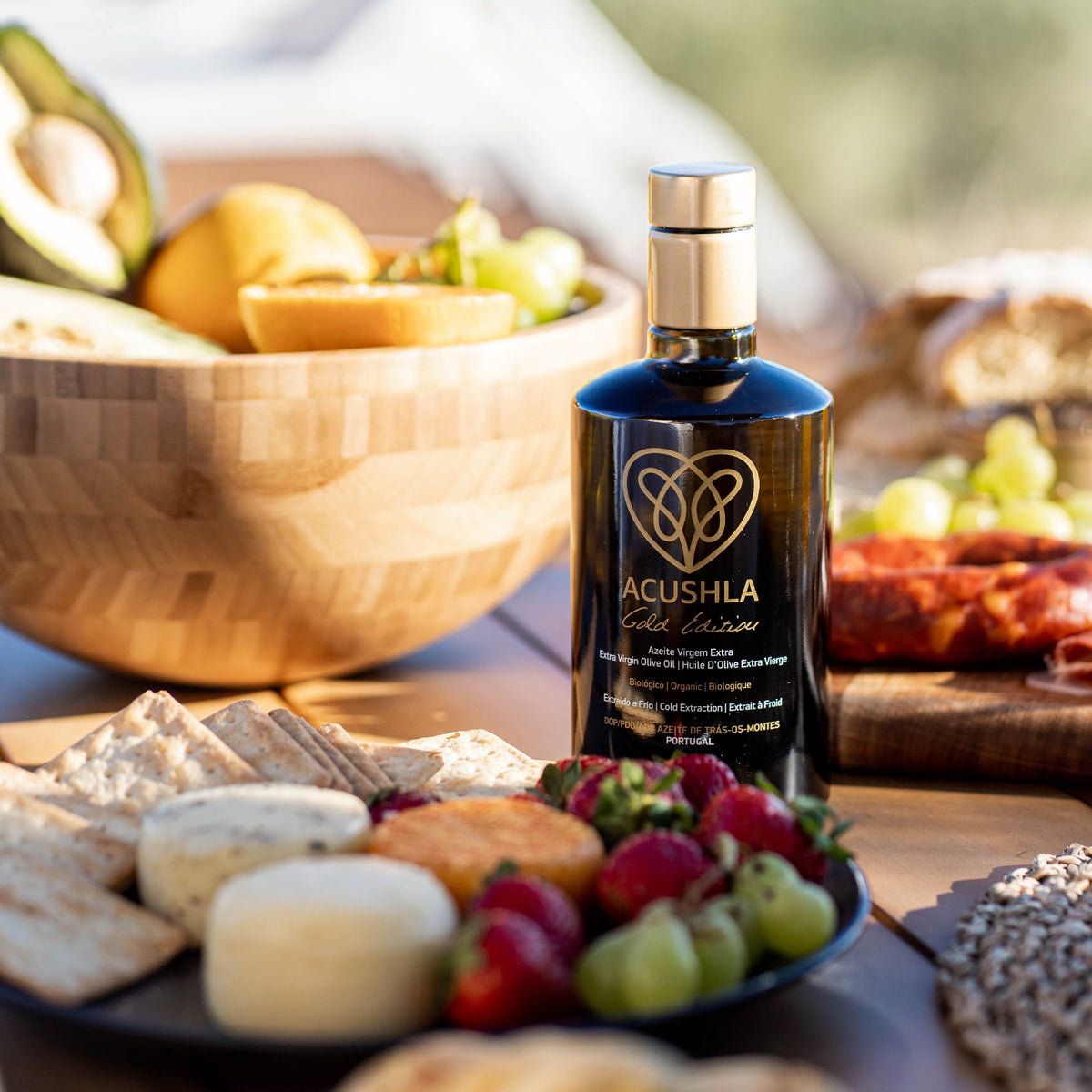 500 ml bottle of Acushla Gold Edition surrounded by cheeses, strawberries, grapes, bread, and avocado.