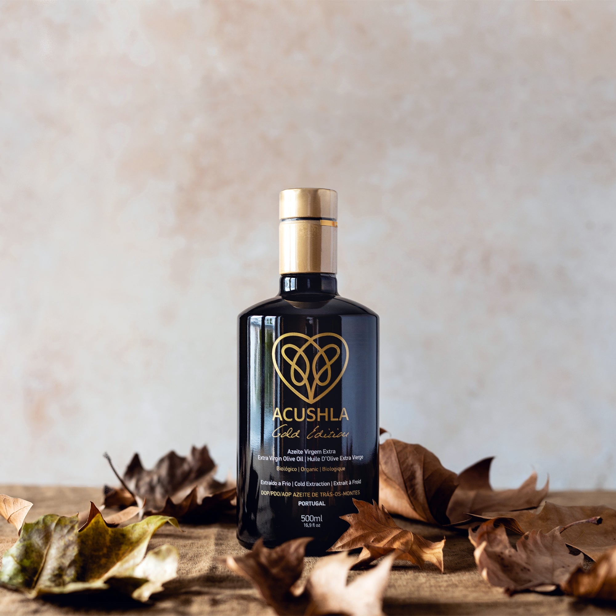 Acushla Gold Edition Organic DOP Trás-os-Montes 500 ml bottle surrounded by dried autumn leaves.