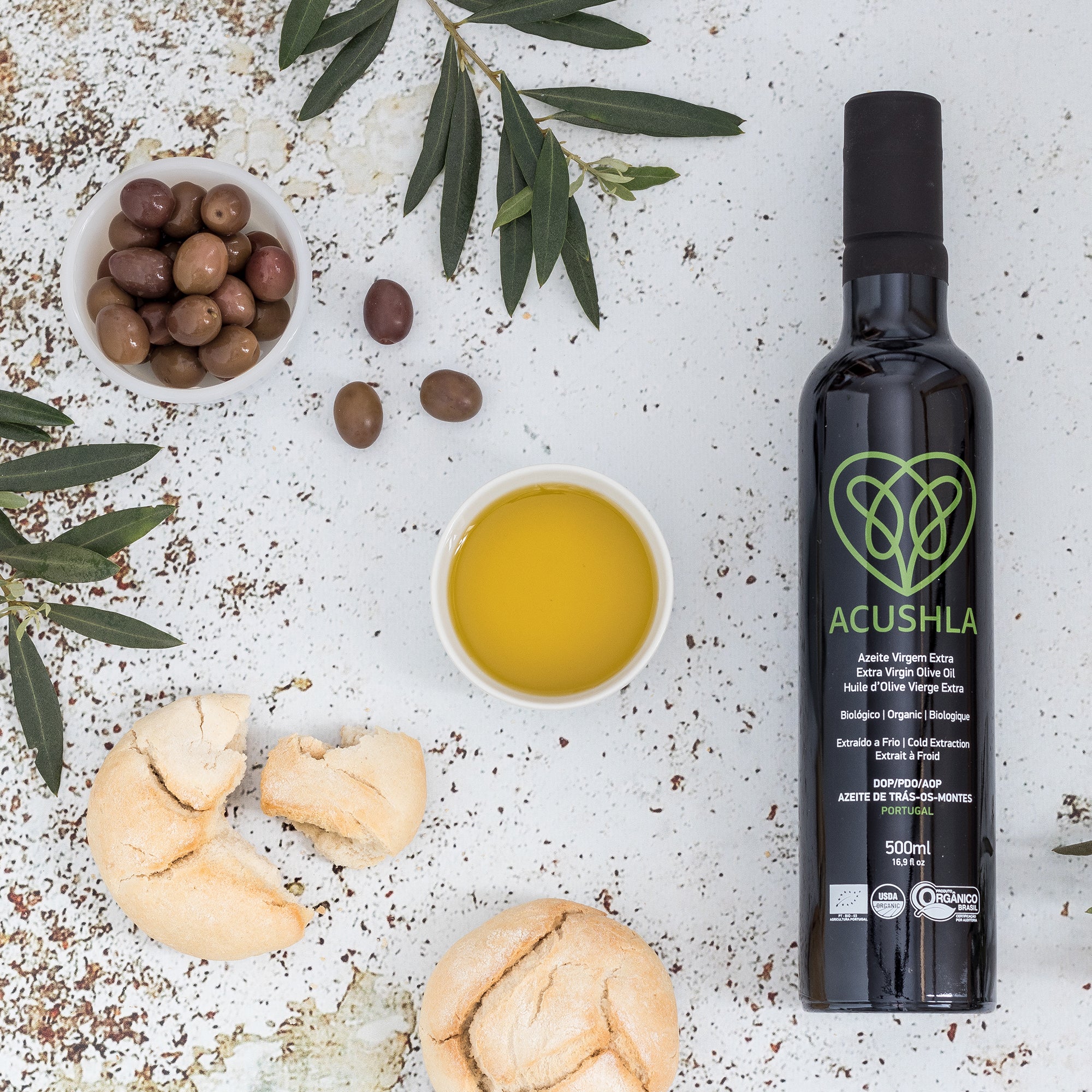Acushla Organic DOP Trás-os-Montes 500 ml bottle with olive oil, olives, bread, and olive branches.