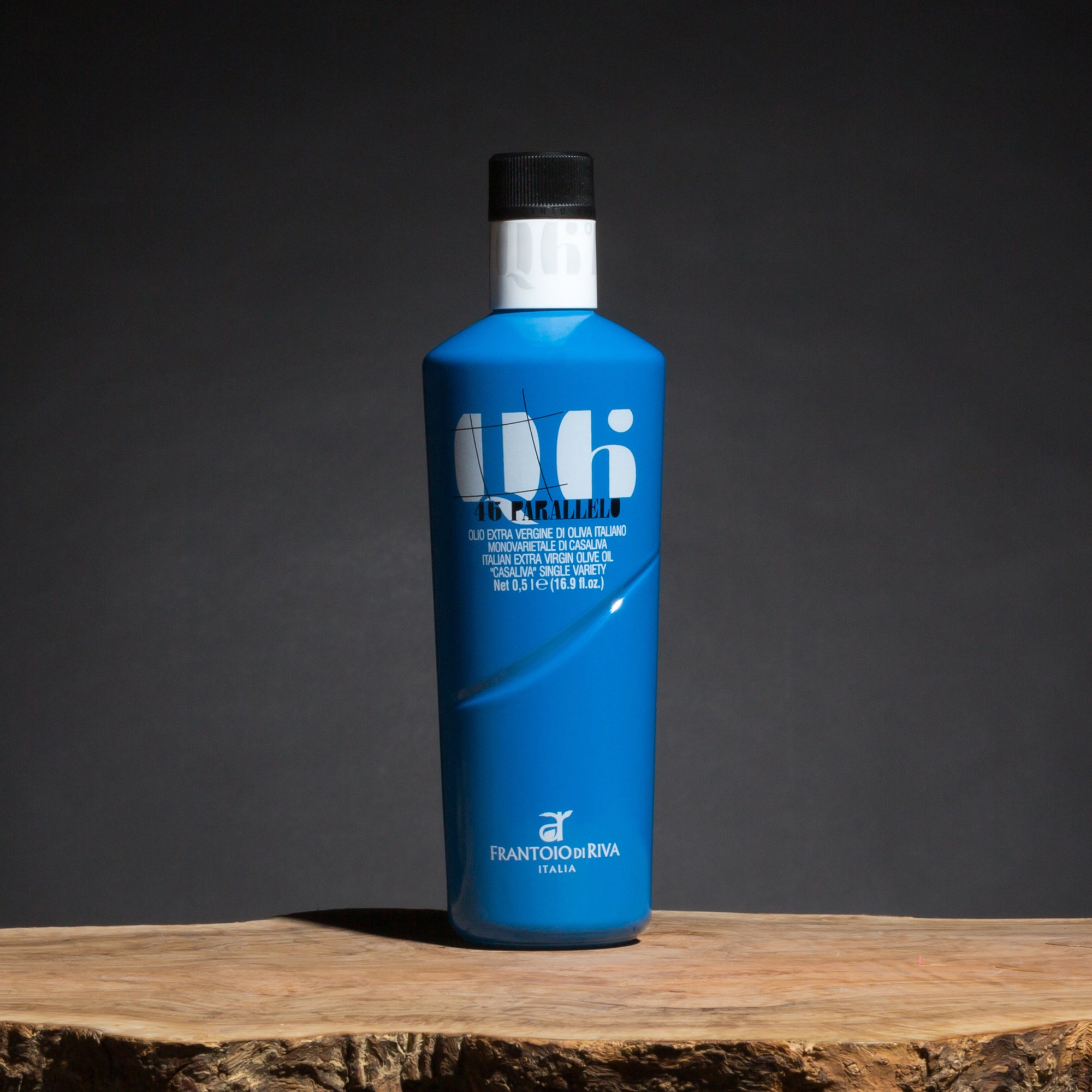 500 ml blue 46° Parallelo Casaliva olive oil bottle on a rustic wooden surface.