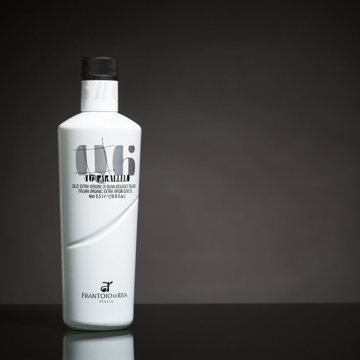 A 500 ml bottle of 46° Parallelo Organic extra virgin olive oil on a reflective surface.