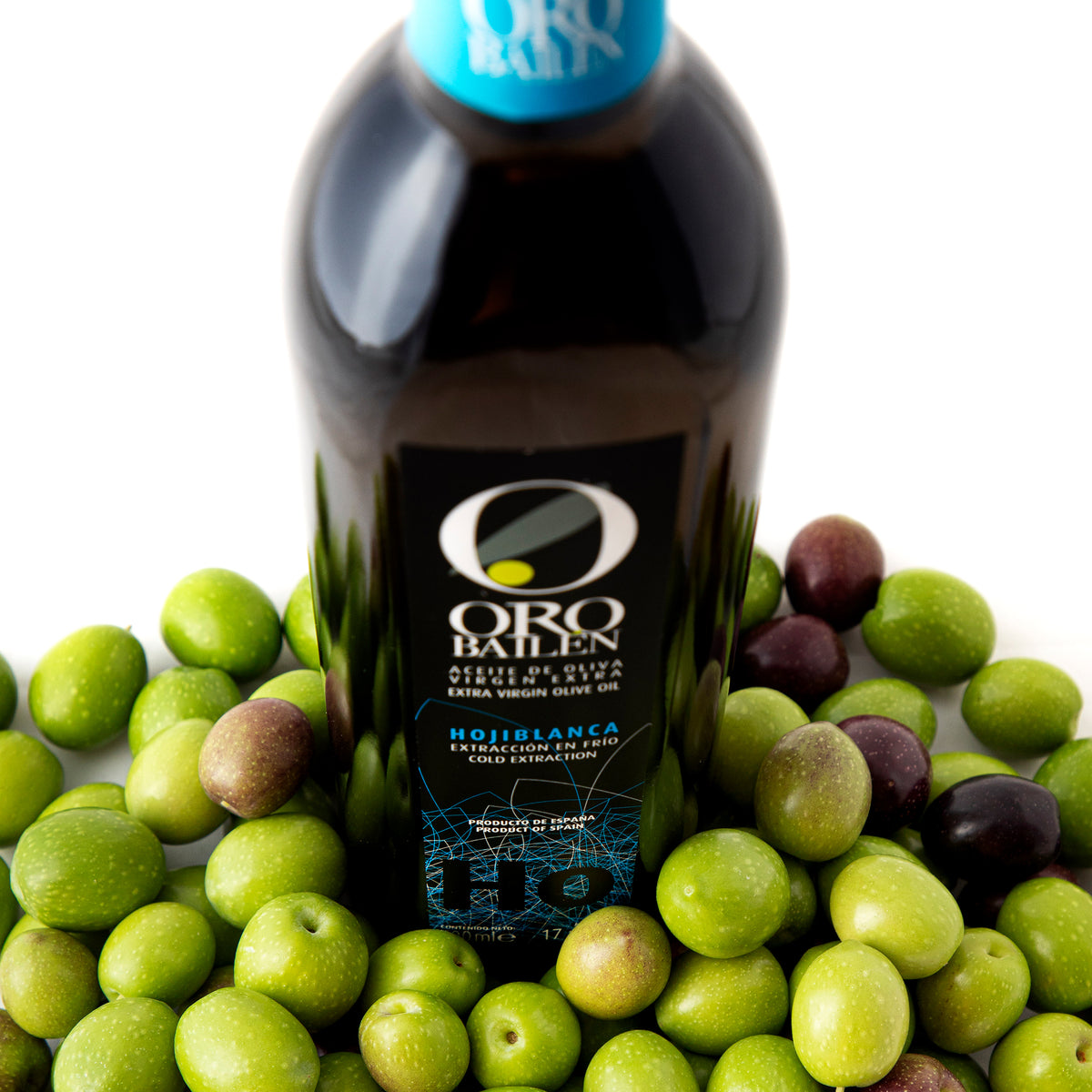 Oro Bailen Hojiblanca 500 ml bottle surrounded by fresh green and purple olives.