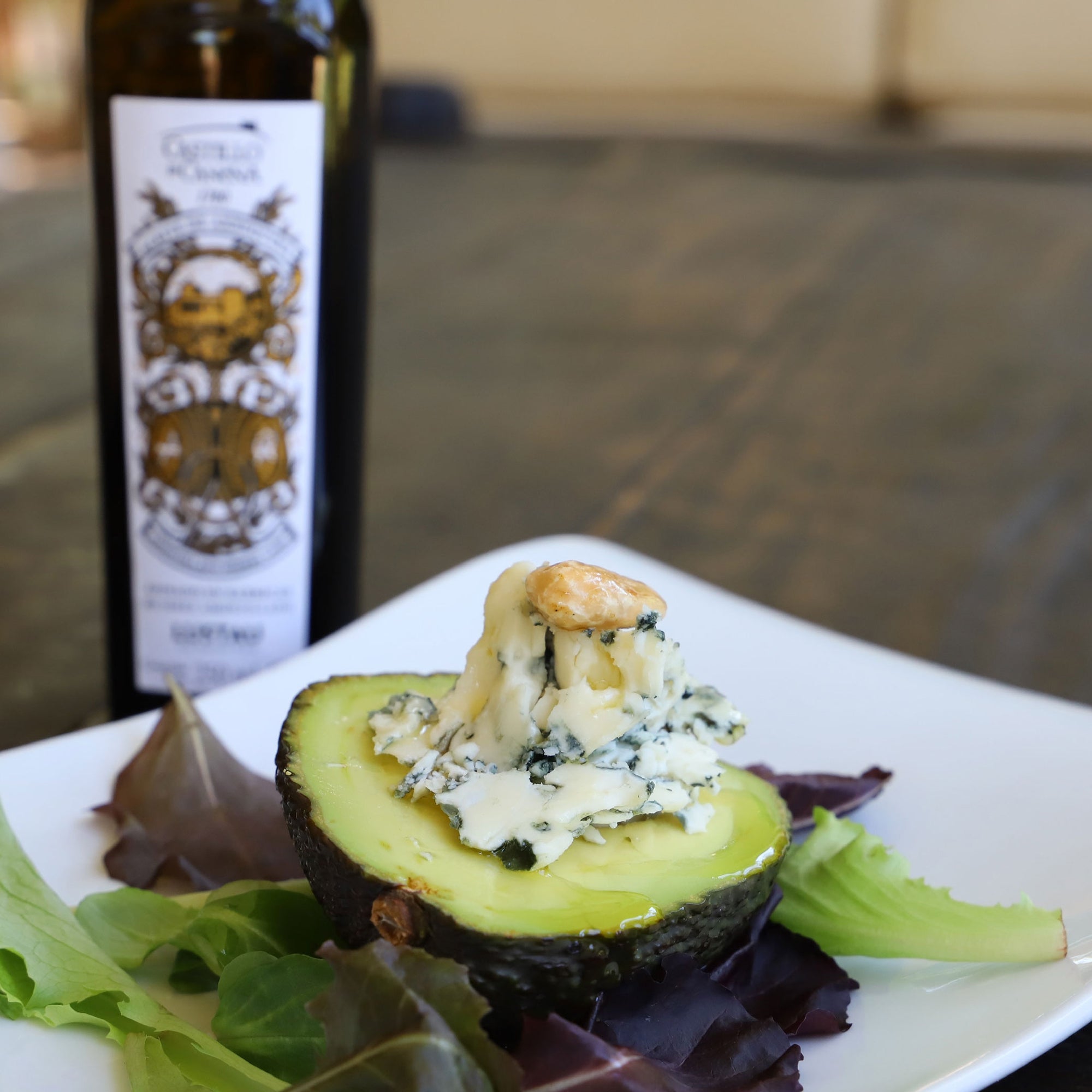 Avocado topped with cheese and olive oil from a Castillo de Canena Arbequina Amontillado Sherry Cask bottle.
