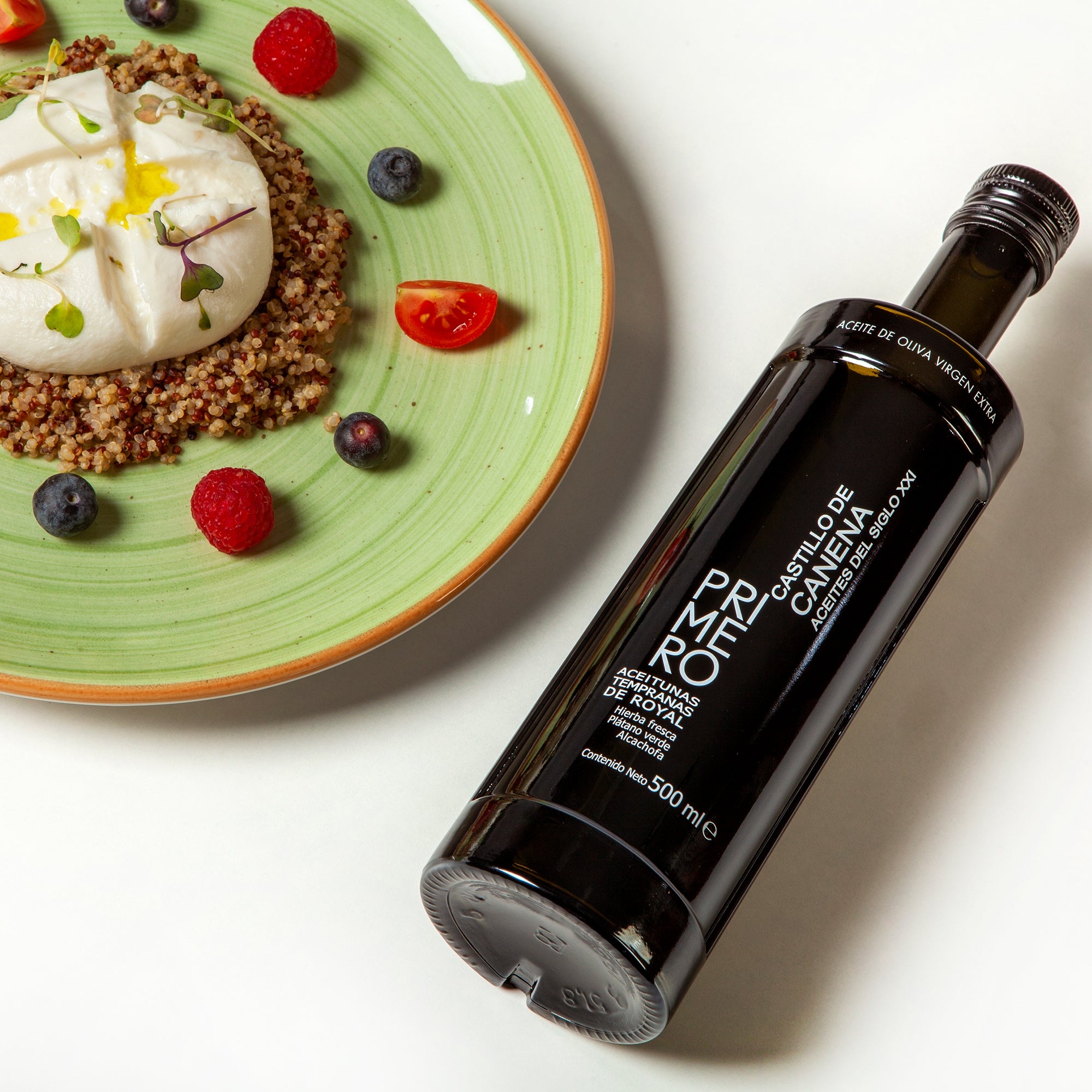 Castillo de Canena Early Royal 500 ml bottle beside quinoa, creamy cheese, berries, and tomatoes.