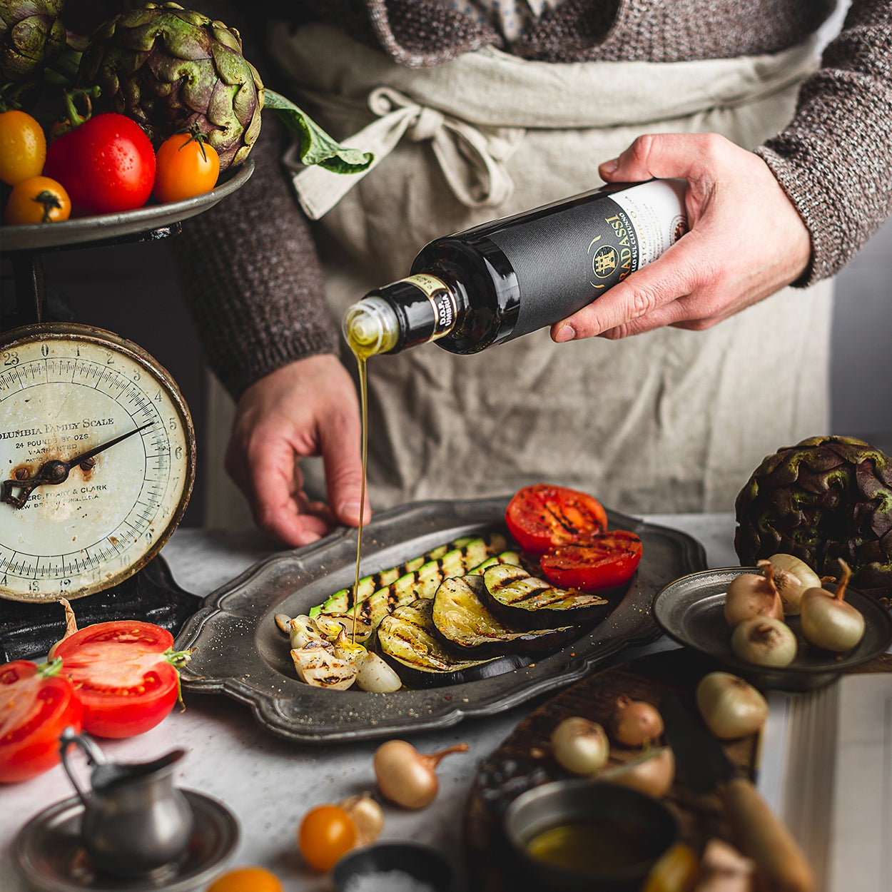 Gradassi Lo Storico 750 ml olive oil poured over grilled zucchini, tomatoes, and onions.