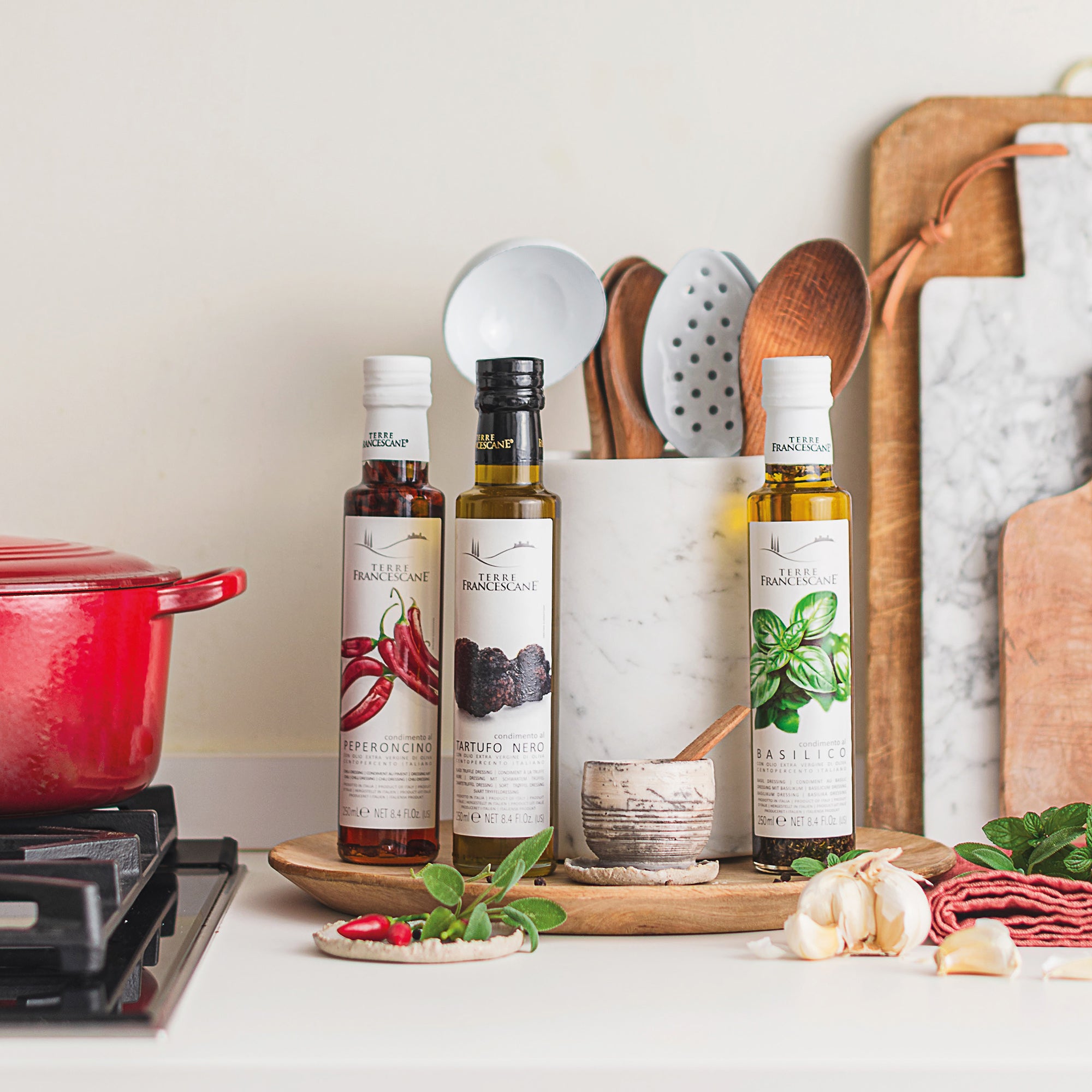 Three 250 ml bottles of Terre Francescane flavored oils; Peperoncino, Black Truffle, and Basil.