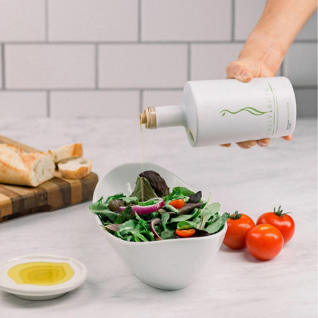 Calivirgin Premium olive oil poured over a fresh mixed-green salad.