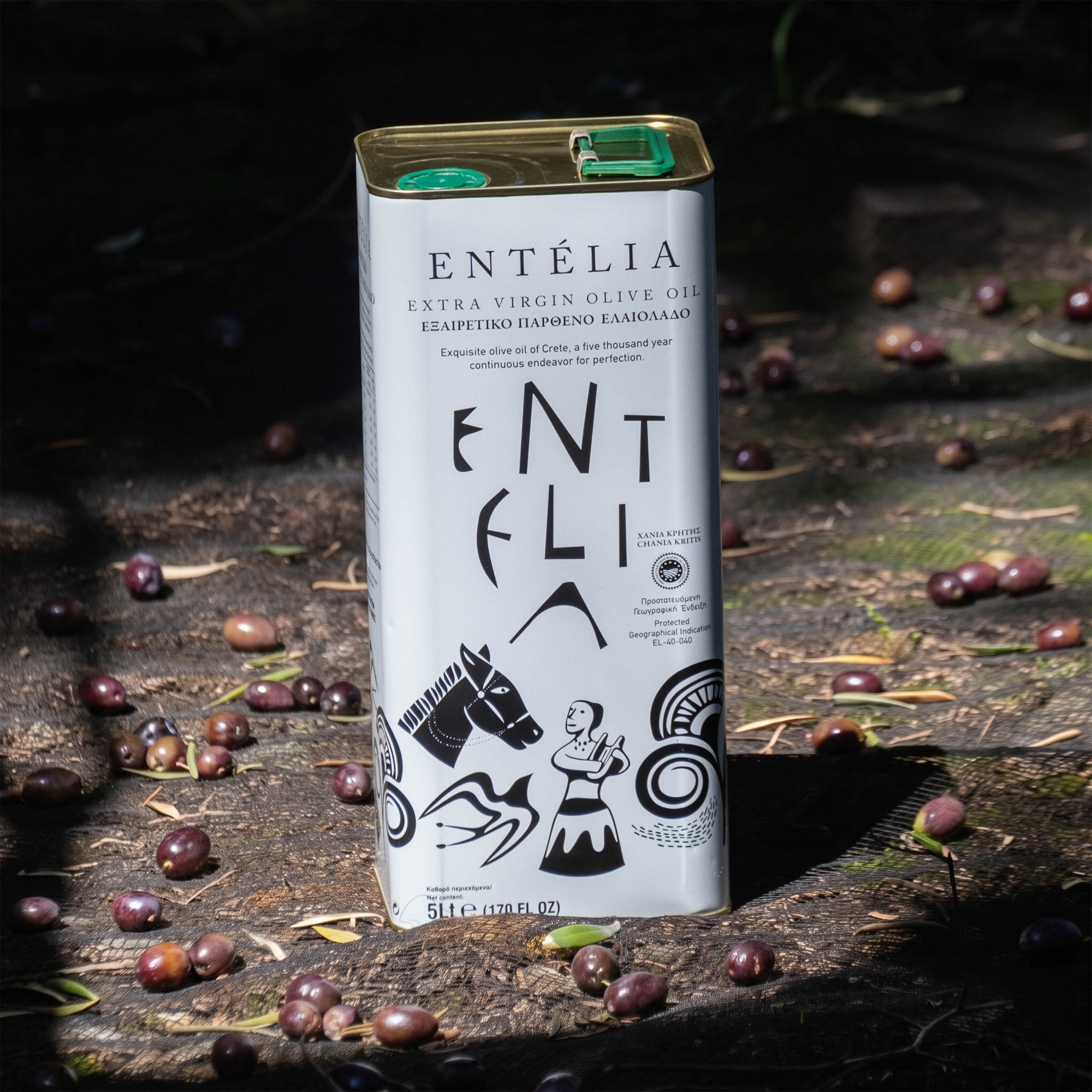 Entelia 5L extra virgin olive oil tin surrounded by freshly harvested olives in a grove.