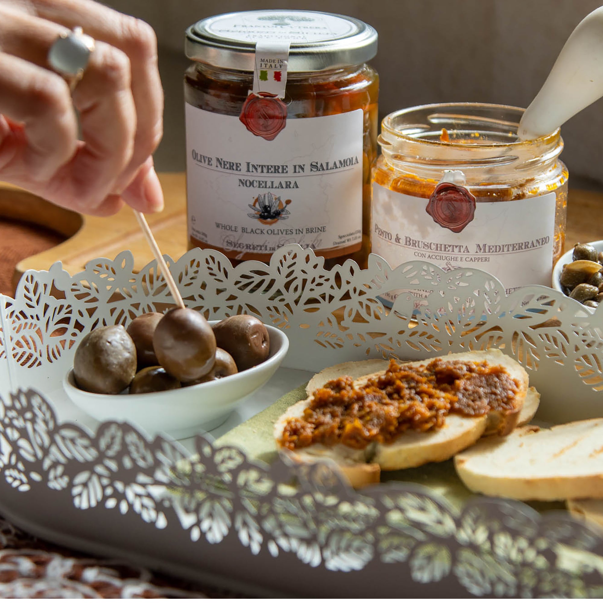 Frantoi Cutrera Black Nocellara del Belice Olives in Brine served with bread and Frantoi Cutrera spreads.