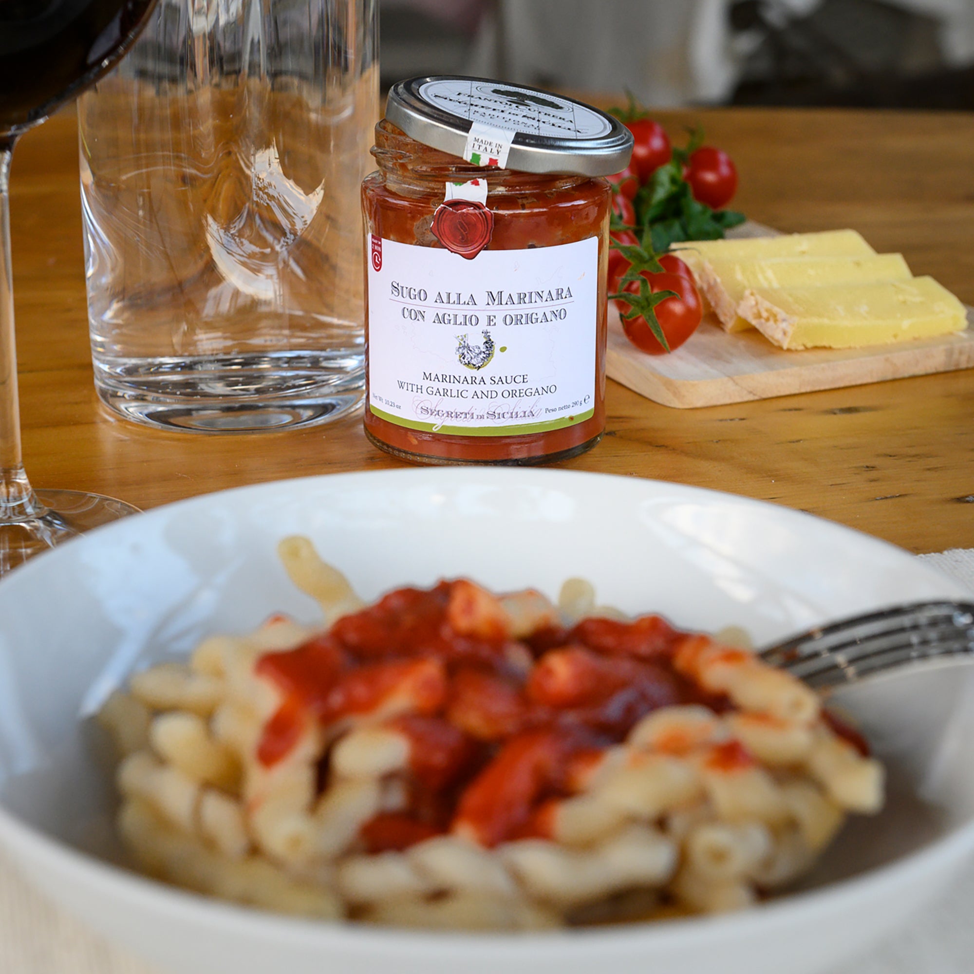 Pasta topped with Frantoi Cutrera Garlic and Oregano Tomato Sauce, with an open jar behind it.