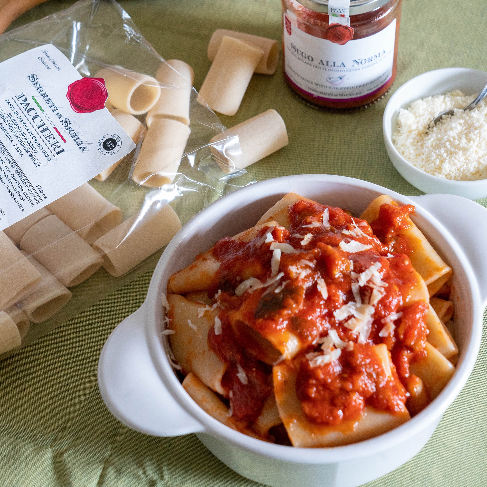 Bowl of Frantoi Cutrera Organic Paccheri topped with Frantoi Cutrera tomato sauce, and grated cheese.