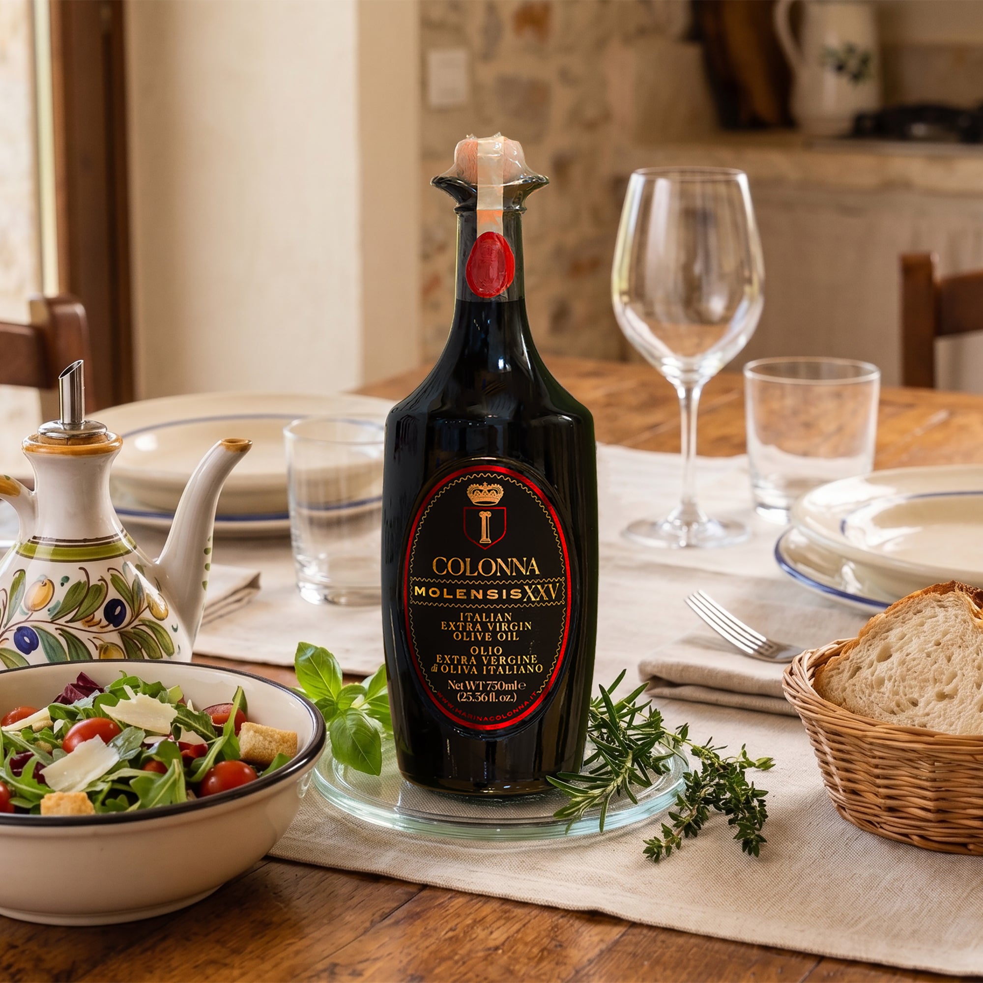 Colonna Molensis XXV 750 ml bottle on dining table beside salad, bread, herbs, and plates.
