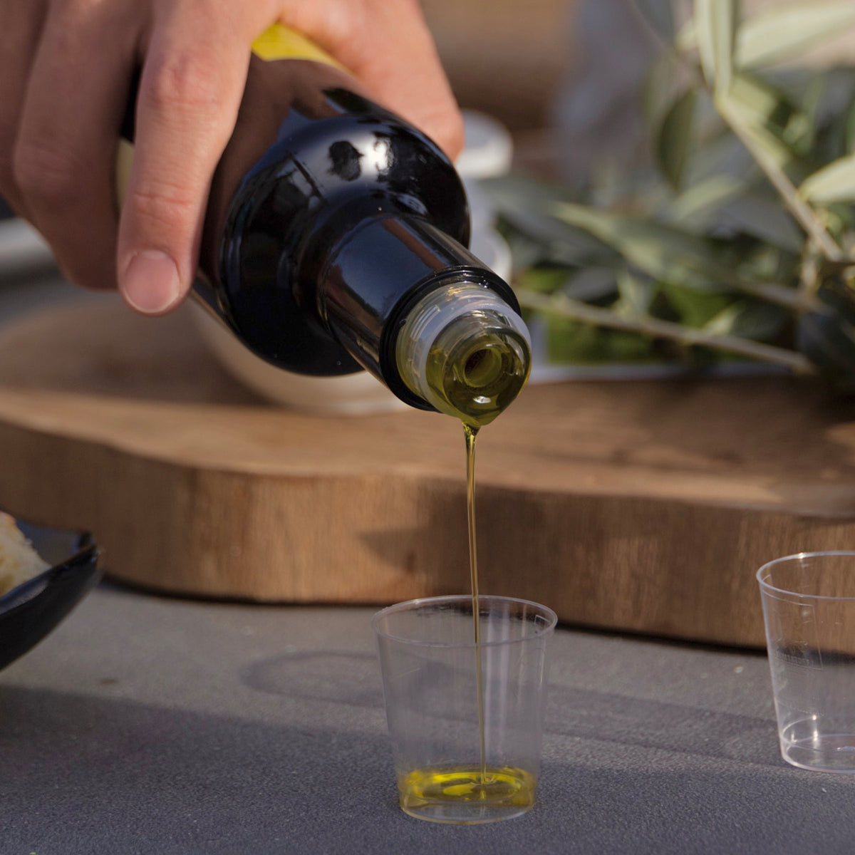 Mandranova extra virgin olive oil being poured into a small tasting cup.
