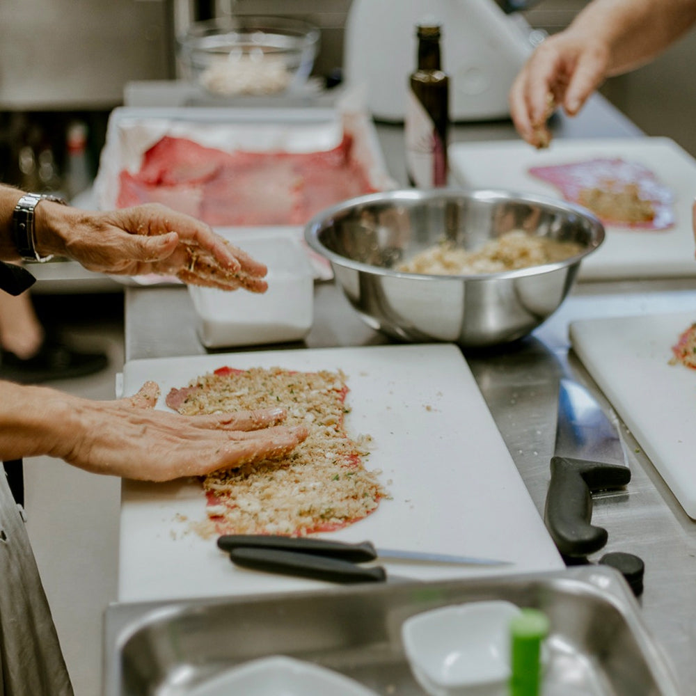 Chefs use Mandranova Cerasuola olive oil while cooking in a professional kitchen.