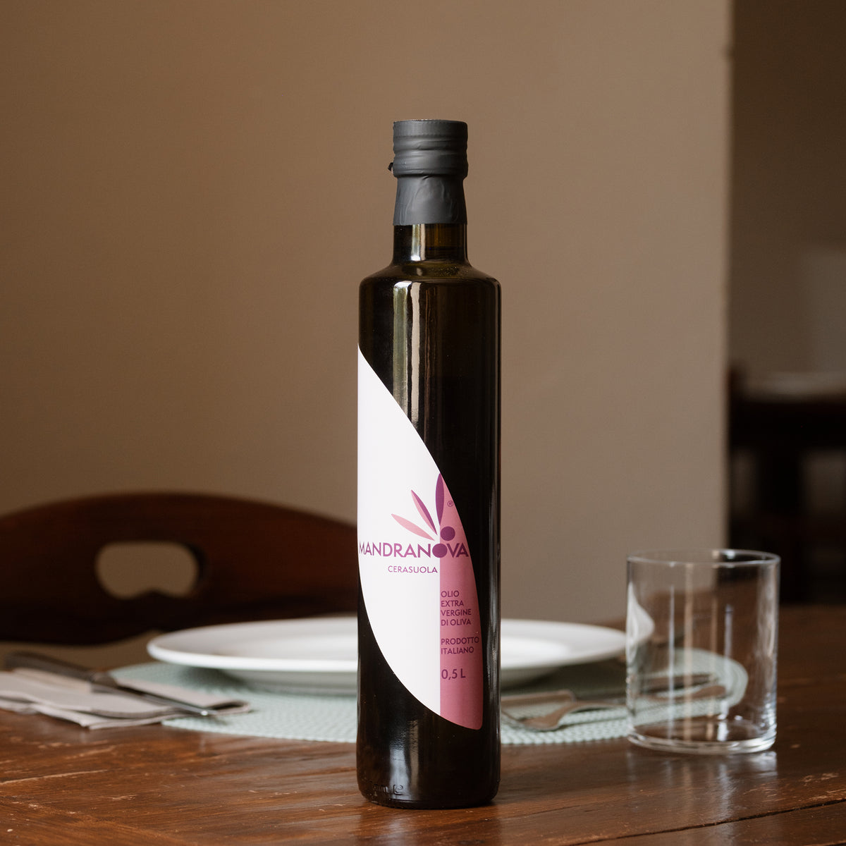 Mandranova Cerasuola extra virgin olive oil bottle on a dining table.