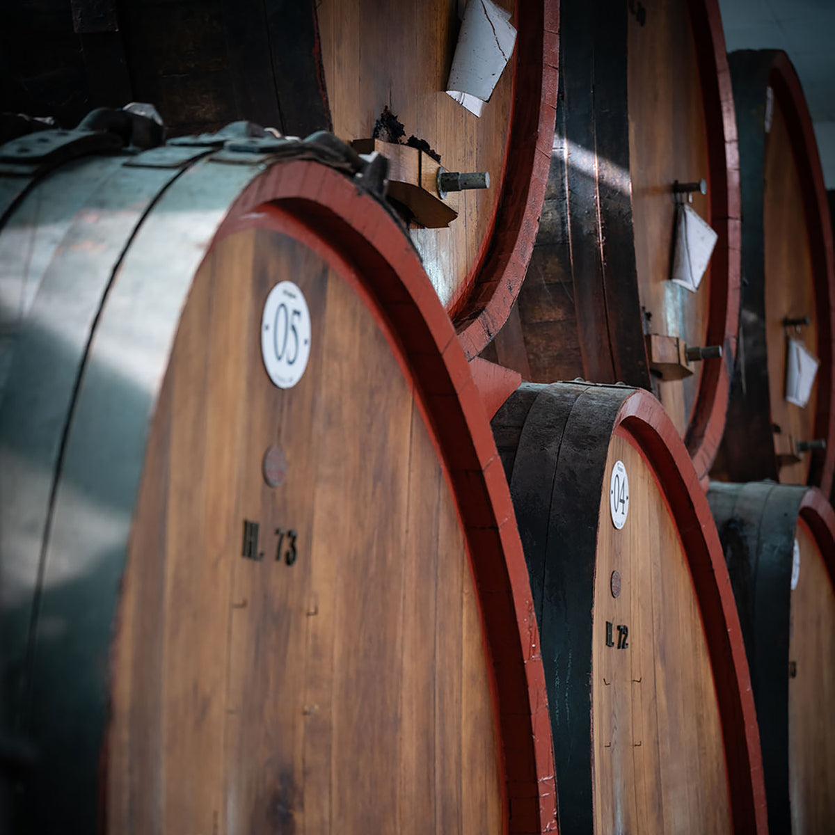 Large wooden barrels used for aging Mussini balsamic vinegar in Italy.