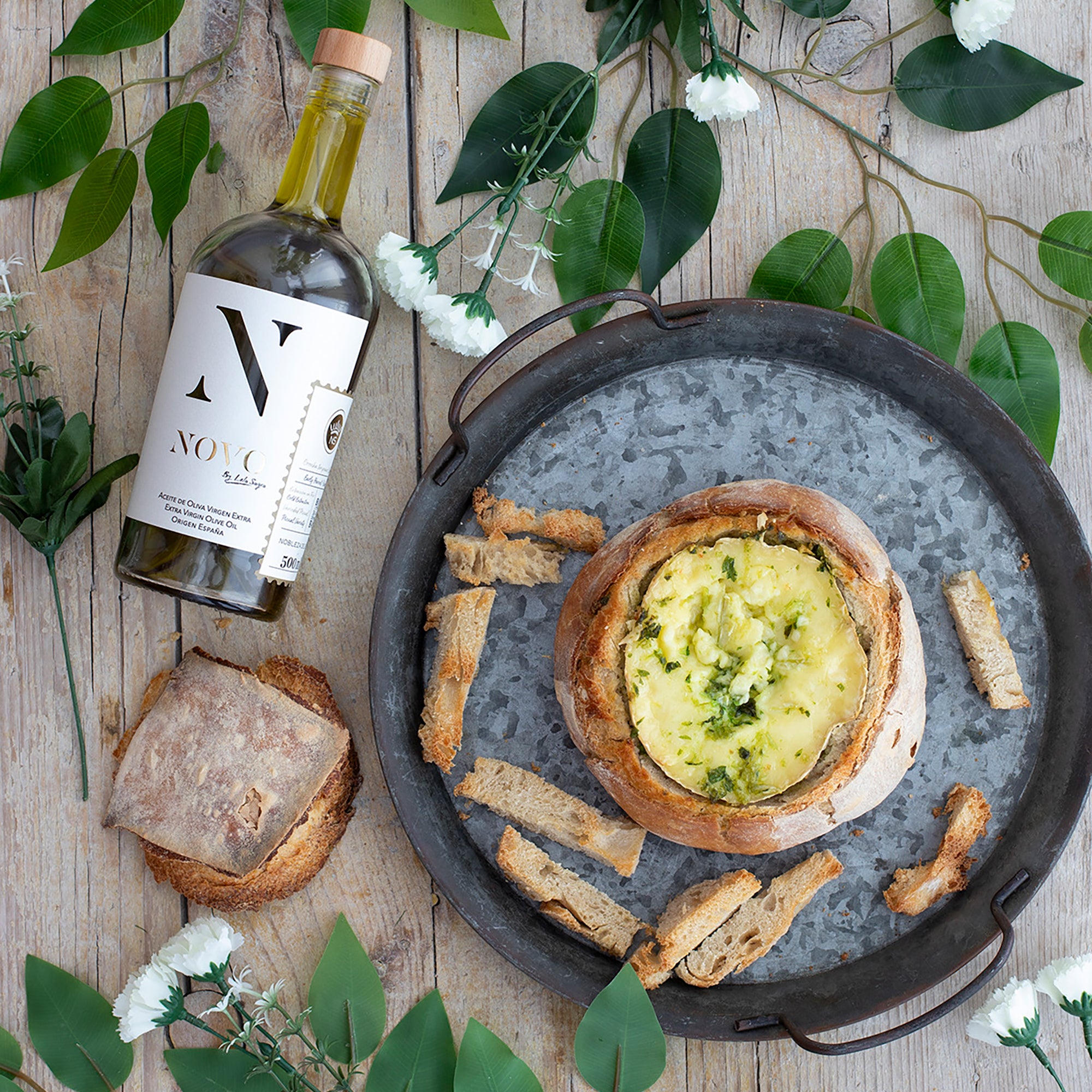 Nobleza del Sur Novo by Lola Sagra 500 ml bottle beside baked cheese in bread.
