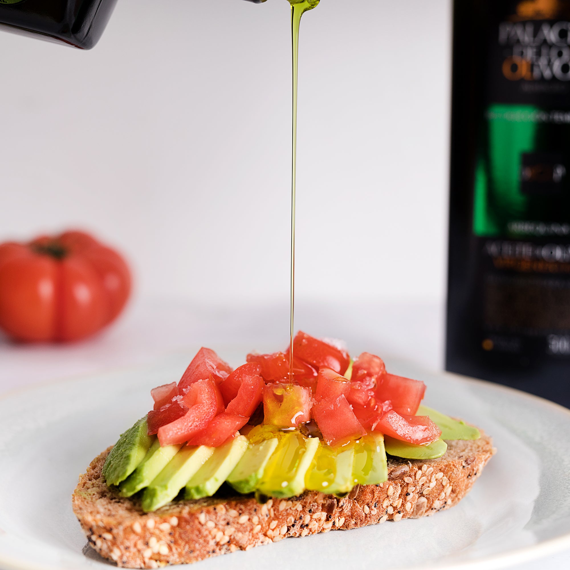 Palacio de los Olivos Arbequina olive oil poured over avocado and chopped tomatoes on seeded bread.